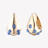 A pair of gold-colored sculptural hoop earrings with lapis lazuli cabochon stones, designed to sit close to the ear.